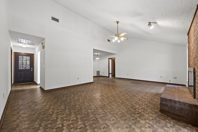 unfurnished living room featuring ceiling fan, a brick fireplace, dark parquet floors, high vaulted ceiling, and a textured ceiling