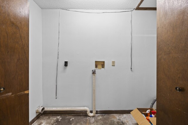 clothes washing area with hookup for an electric dryer, washer hookup, and a textured ceiling