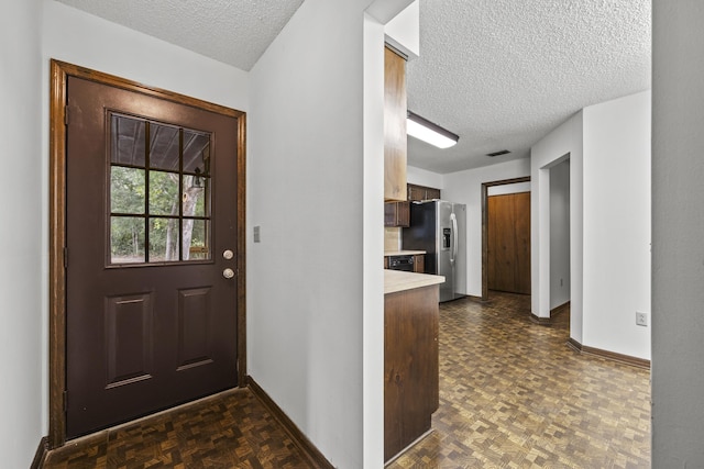 entryway featuring dark parquet floors and a textured ceiling