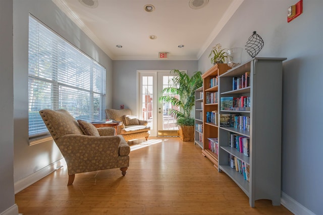 living area with light hardwood / wood-style flooring and crown molding