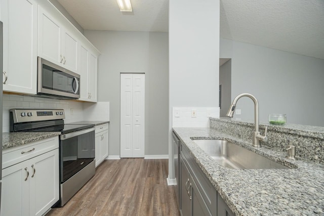 kitchen with a textured ceiling, white cabinetry, sink, and appliances with stainless steel finishes