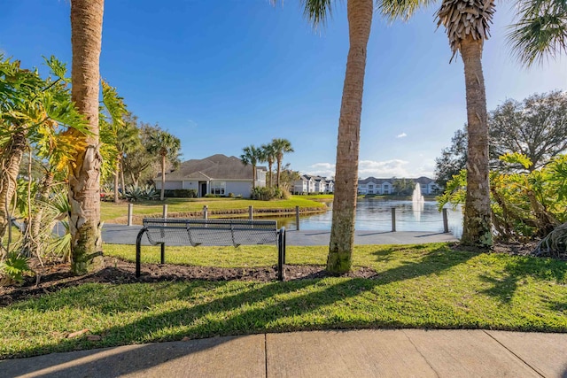 surrounding community with a lawn and a water view