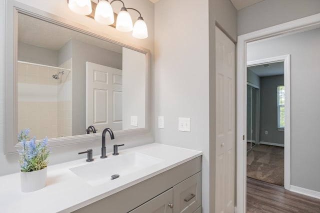 bathroom featuring walk in shower, vanity, and hardwood / wood-style flooring