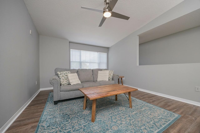 living room with a textured ceiling, dark hardwood / wood-style floors, and ceiling fan