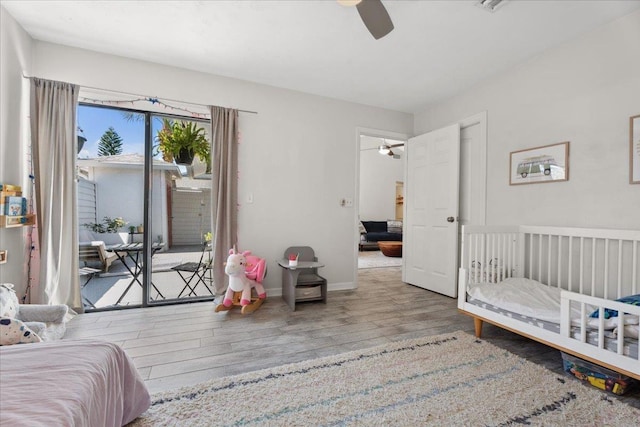 bedroom featuring access to exterior, ceiling fan, baseboards, and wood finished floors