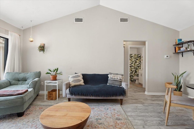 sitting room with light wood-type flooring, lofted ceiling, and visible vents