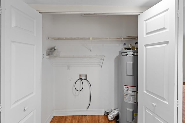 laundry area featuring water heater, light wood-type flooring, and hookup for a washing machine