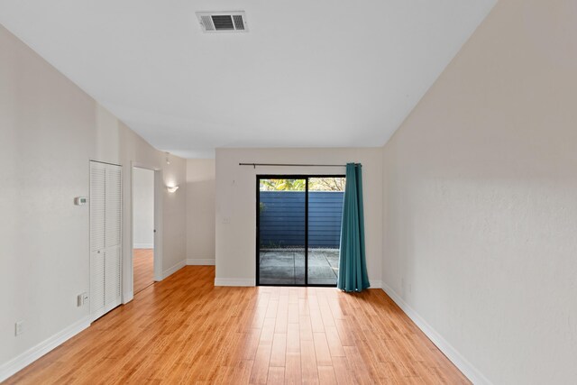 empty room with vaulted ceiling, light wood-type flooring, and ceiling fan