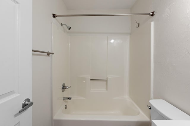 bathroom with shower / bathing tub combination and toilet