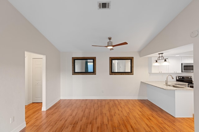 unfurnished living room with vaulted ceiling, ceiling fan, light hardwood / wood-style flooring, and sink