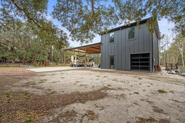 exterior space featuring an outbuilding, driveway, a carport, a garage, and board and batten siding