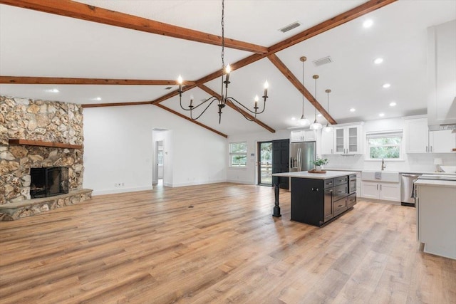 kitchen featuring stainless steel appliances, visible vents, open floor plan, and a center island