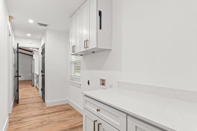 kitchen featuring white cabinetry, light countertops, visible vents, and light wood-type flooring