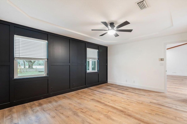 unfurnished bedroom featuring a ceiling fan, light wood-style flooring, visible vents, and baseboards