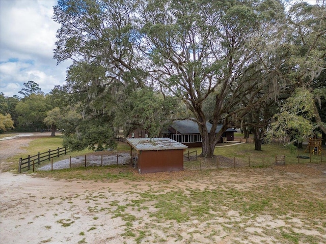 view of yard with an outdoor structure and fence