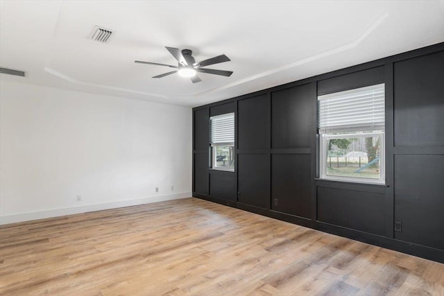 unfurnished bedroom with visible vents, multiple windows, and light wood finished floors