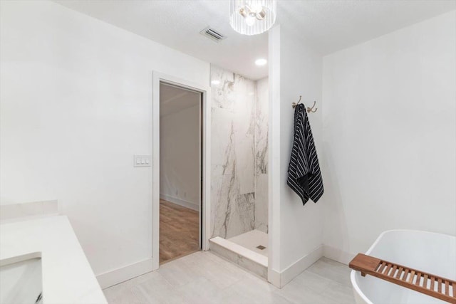 bathroom featuring a soaking tub, baseboards, visible vents, and a marble finish shower