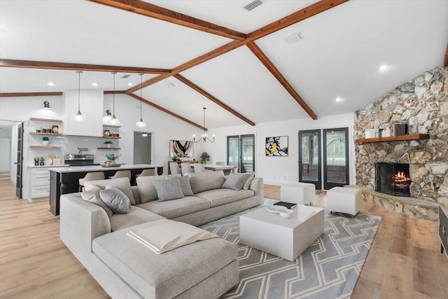 living room featuring a chandelier, a stone fireplace, light wood-style flooring, and beam ceiling