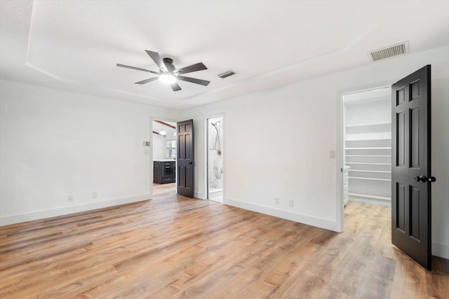 unfurnished room featuring ceiling fan, baseboards, visible vents, and light wood-type flooring