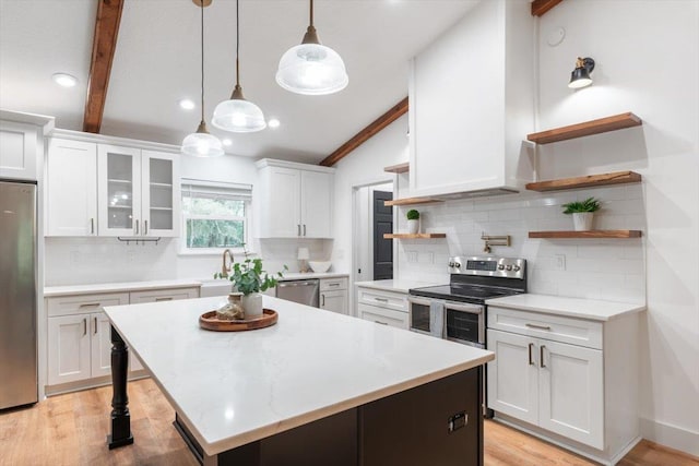 kitchen with a kitchen island, vaulted ceiling with beams, appliances with stainless steel finishes, white cabinets, and open shelves