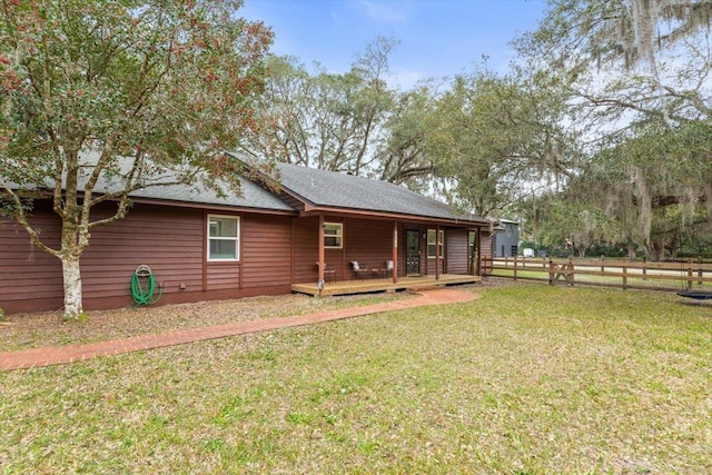 back of property featuring a yard, fence, and a wooden deck