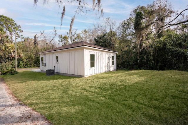 view of outbuilding featuring central AC and a lawn