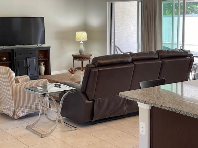living area featuring light tile patterned floors and baseboards