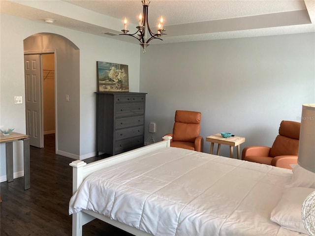 52 Fanshawe Ln, Palm Coast, FL 32137 - bedroom featuring arched walkways, baseboards, dark wood-type flooring, and a chandelier