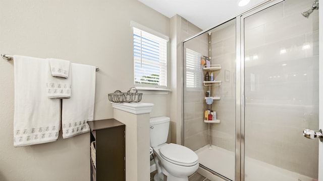 bathroom featuring toilet and an enclosed shower