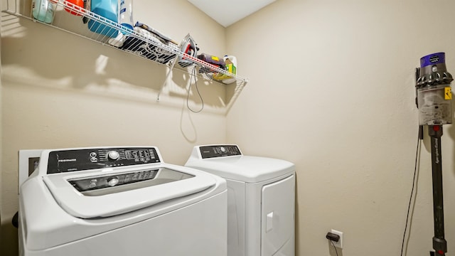 clothes washing area with separate washer and dryer