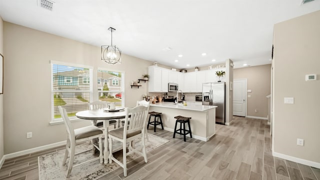 dining space featuring light hardwood / wood-style flooring and a notable chandelier