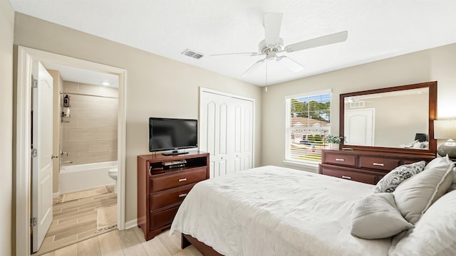 bedroom featuring ceiling fan, light hardwood / wood-style floors, ensuite bathroom, and a closet