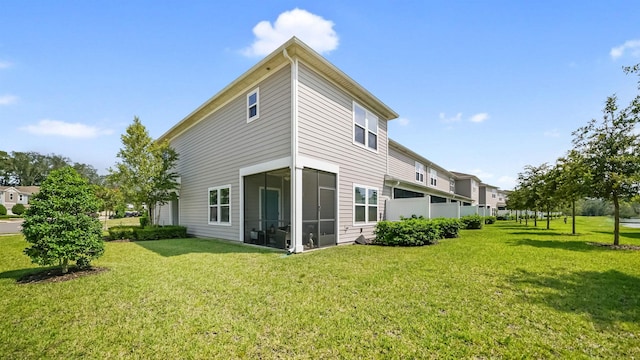 back of property featuring a sunroom and a yard