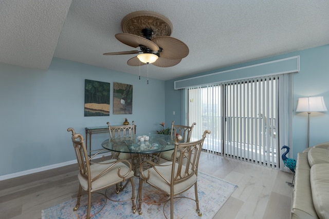 dining room with ceiling fan, light wood-type flooring, and a textured ceiling