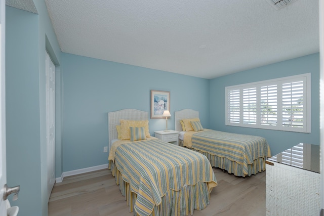 850 A1A Beach Blvd Unit 74, Saint Augustine Beach, FL 32080 - bedroom with wood finished floors, a textured ceiling, a closet, and baseboards