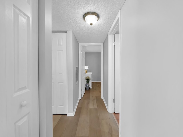 850 A1A Beach Blvd Unit 74, Saint Augustine Beach, FL 32080 - hall featuring a textured ceiling, light wood-style flooring, and baseboards