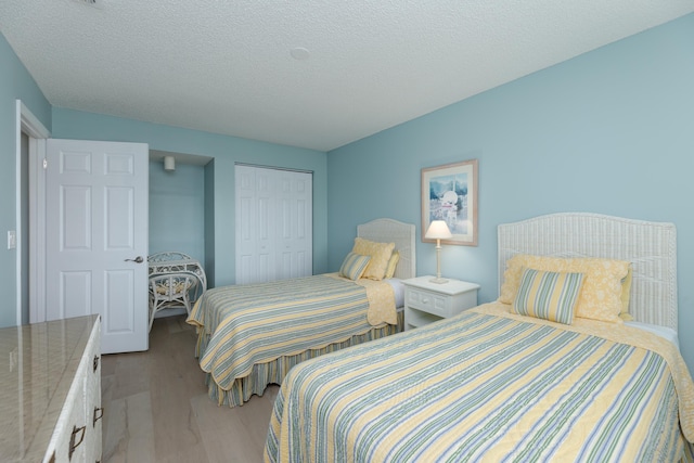 850 A1A Beach Blvd Unit 74, Saint Augustine Beach, FL 32080 - bedroom with light wood-type flooring, a closet, and a textured ceiling