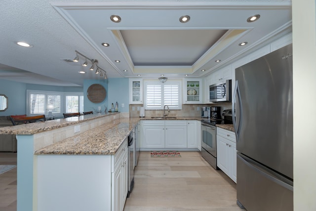 850 A1A Beach Blvd Unit 74, Saint Augustine Beach, FL 32080 - kitchen featuring appliances with stainless steel finishes, a peninsula, glass insert cabinets, white cabinets, and a tray ceiling