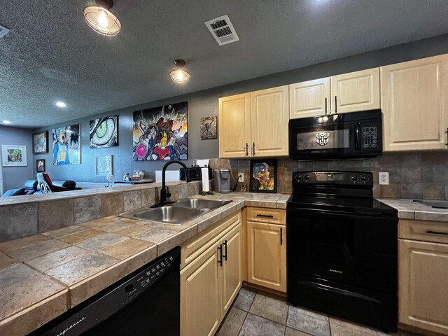 650 W Pope Rd Unit 251, Saint Augustine, FL 32080 - kitchen with black appliances, a sink, stone tile floors, tile countertops, and a peninsula