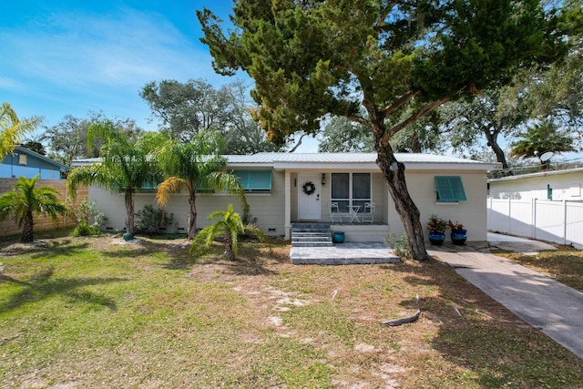 single story home featuring a front yard, crawl space, metal roof, and fence