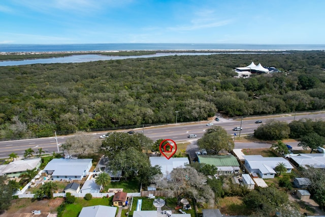 birds eye view of property featuring a water view and a view of trees