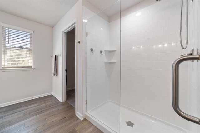 bathroom featuring hardwood / wood-style flooring and a shower with door