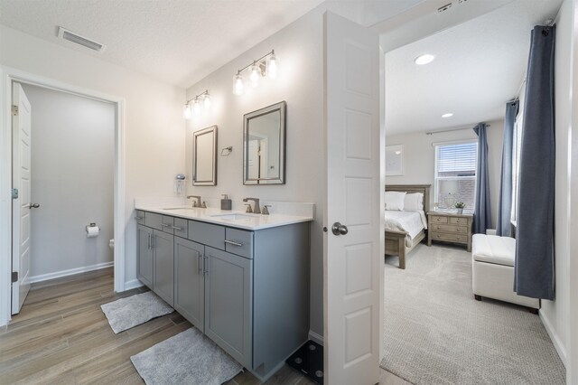 bathroom with vanity, wood-type flooring, toilet, and a textured ceiling