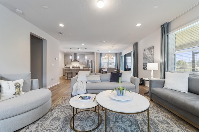 living room with an inviting chandelier, hardwood / wood-style flooring, and a wealth of natural light