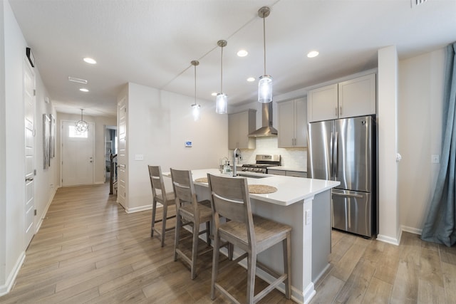 kitchen with pendant lighting, sink, gray cabinets, appliances with stainless steel finishes, and a kitchen island with sink