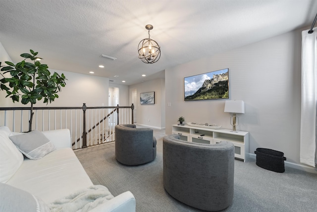 carpeted living room featuring a notable chandelier and a textured ceiling