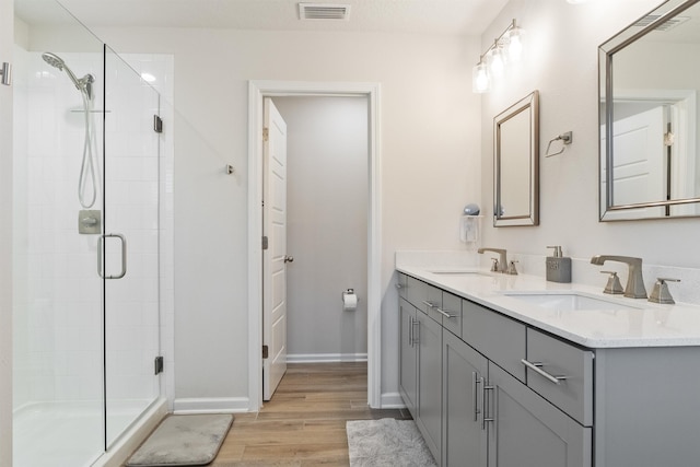 bathroom featuring wood-type flooring, an enclosed shower, and vanity