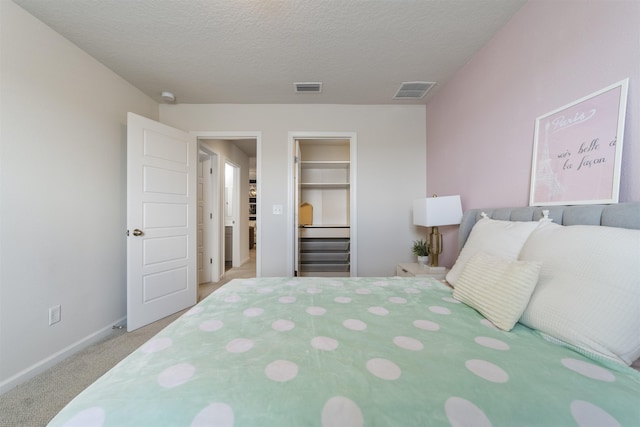 carpeted bedroom with a spacious closet, a closet, and a textured ceiling