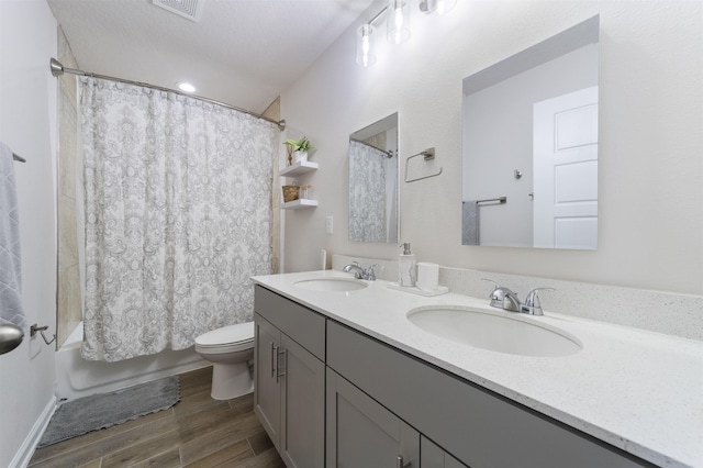 full bathroom featuring shower / bath combination with curtain, vanity, and toilet