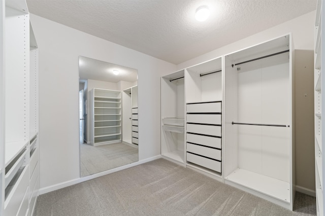 walk in closet featuring light carpet